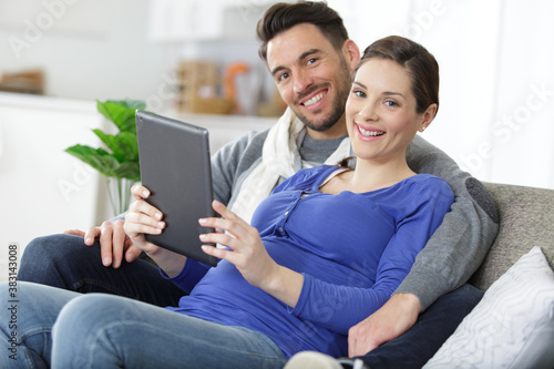 pregnant woman and her husband using a digital tablet