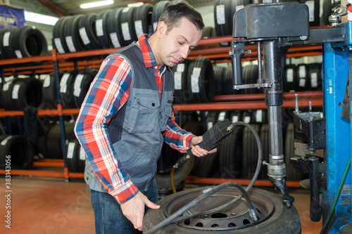 vulcanizing worker removing the rim using a tire clamp © auremar