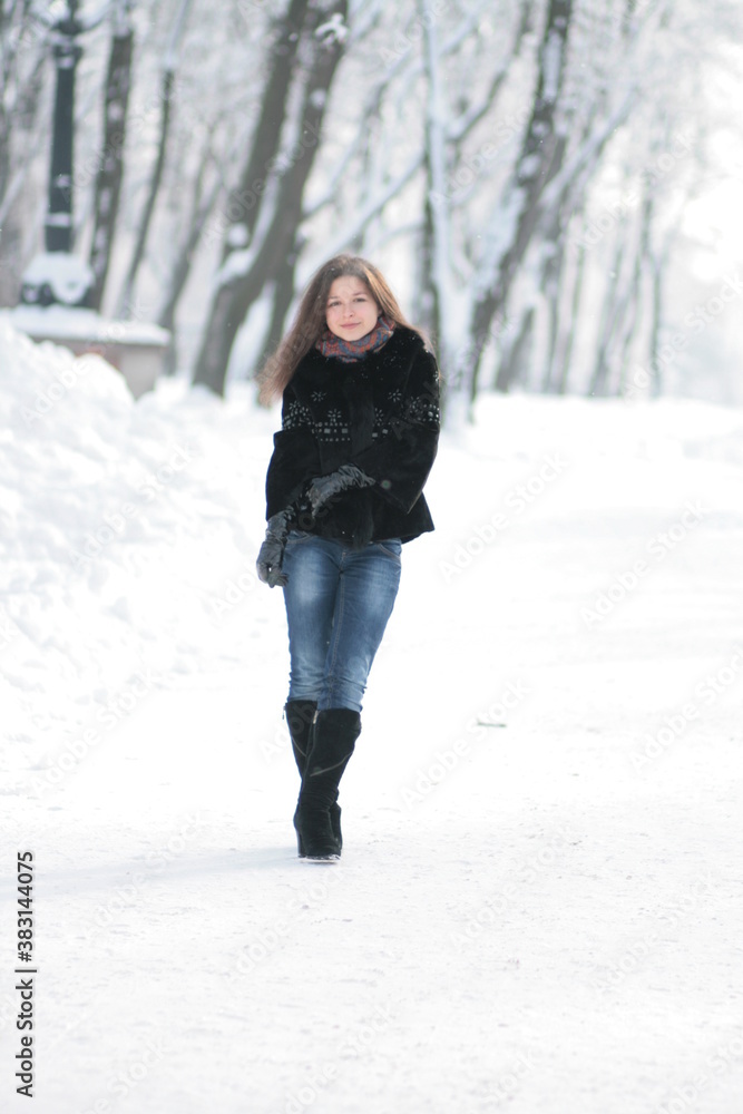 A cute girl walks in the winter through the forest A cute girl walks in the winter through the forest
