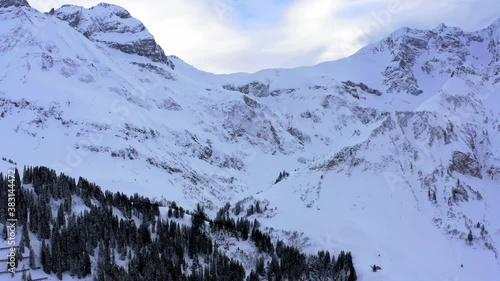 mountain view from the food of the hill to the peak. 
snow covered hill in the alps in austria. lovely sky and vallay view