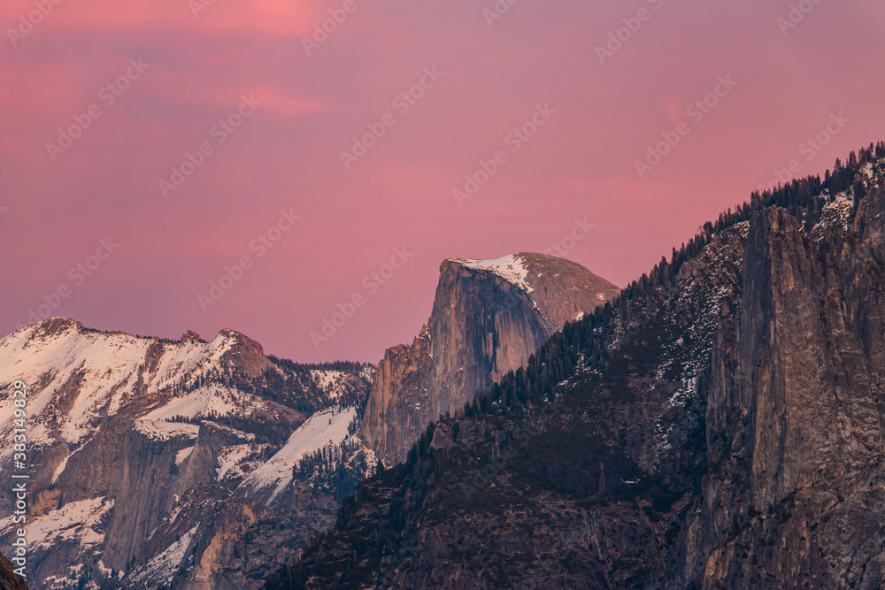 Snowy Half Dome bathed in a winter sunset.