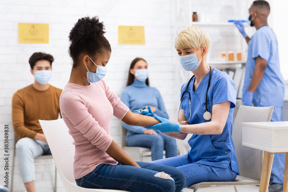 African American Teen Girl Receiving Coronavirus Vaccine Injection In Hospital African American Teen Girl Receiving Coronavirus Vaccine Injection In Hospital