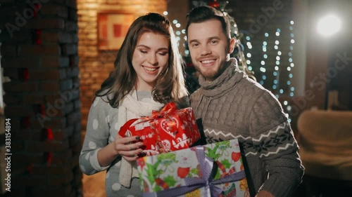 A young couple are holding christmas presents. photo