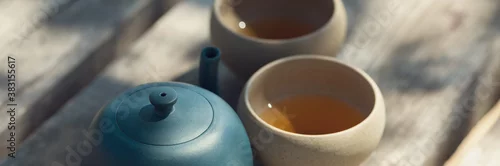 Panel kuchenny z motywem Chinese tea ceremony. Ceramic teapot made of clay and bowls on a wooden background.