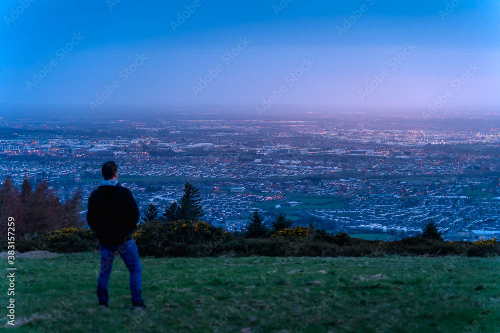Fototapeta premium Defocused man silhouette watching how twilight begins yielding to daylight at Dublin city