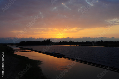 Sunset rays over solar panels on the lake.