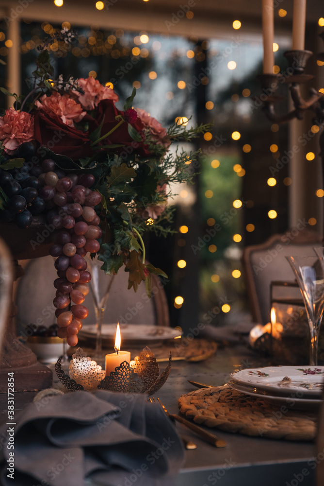 Christmas table with candles, flowers and glass cups.