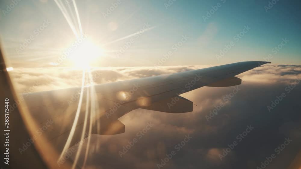 Airplane flight. Wing of an airplane flying above the clouds with sunset sky. Airplane flight. Wing of an airplane flying above the clouds with sunset sky.