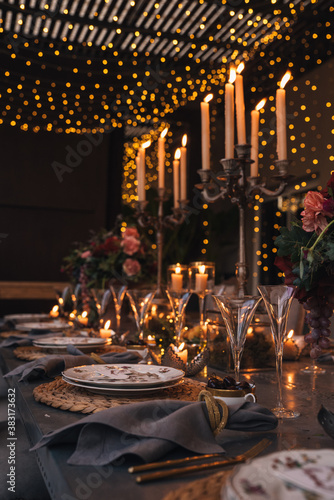 Christmas table with candles, flowers and fruits