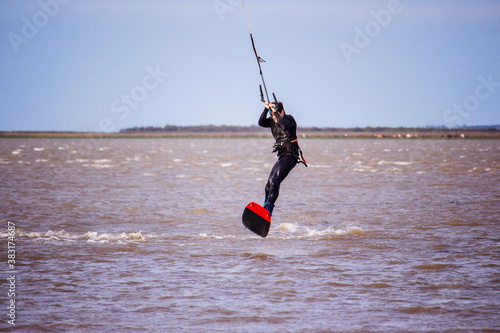 man jumping into the water while kitesurfing - lagoon