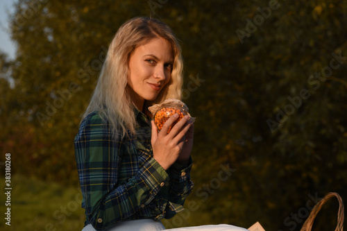Smiling girl with a jar of sea buckthorn in the autumn forest against a blurred background