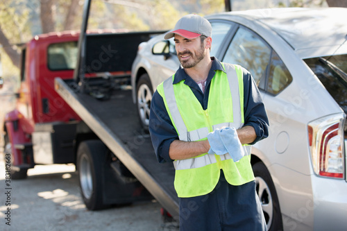 Konstfotografi Smiling male roadside assistance worker towing car3/28/2020