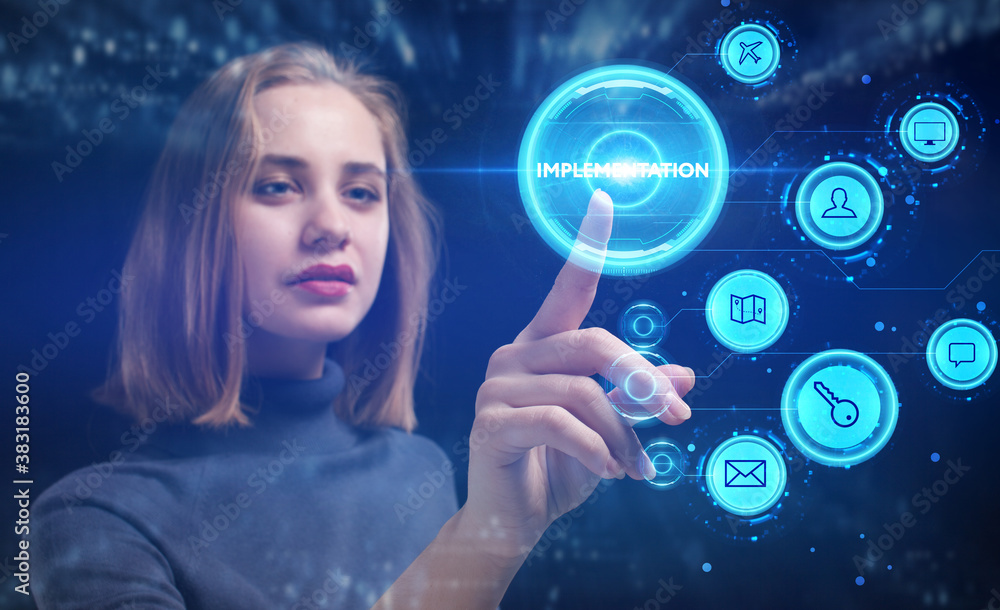 Business, Technology, Internet and network concept. Young businessman working on a virtual screen of the future and sees the inscription: Implementation Business, Technology, Internet and network concept. Young businessman working on a virtual screen of the future and sees the inscription: Implementation