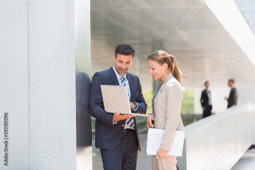 Corporate business people using laptop outdoors