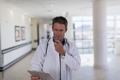Фотография Male doctor dictating notes into tape recorder in hospital