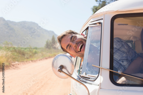 Cuadro en lienzo Portrait happy young man leaning out sunny van window