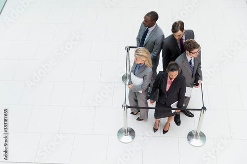 Business people trapped in square stanchions