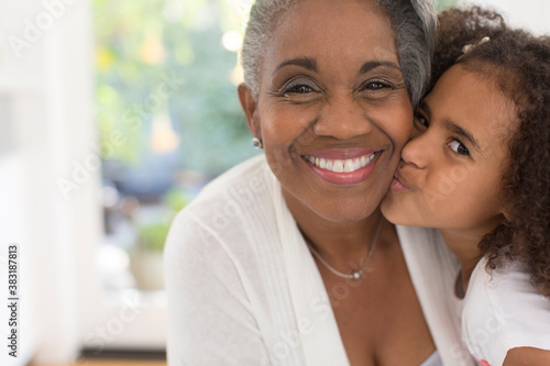 Canvas Print Close up portrait cute granddaughter kissing grandmother on cheek