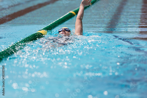 Fotografie Female swimmer practicing backstroke in swimming pool