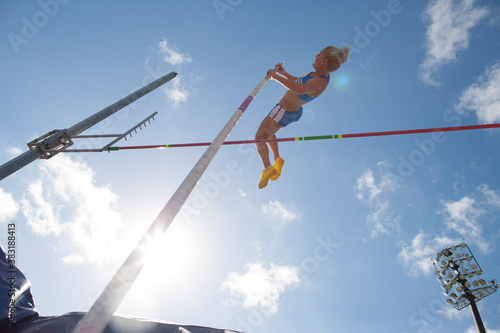Photos Female track and field athlete pole vaulting under sunny sky