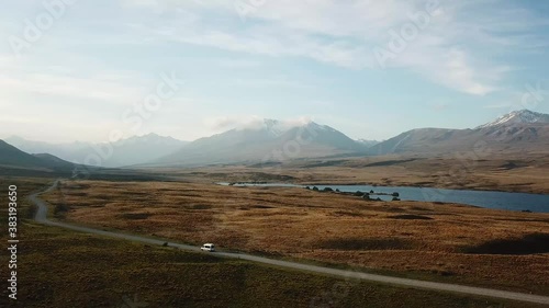 Aerial drone Van driving on long winding road through open mountain countryside