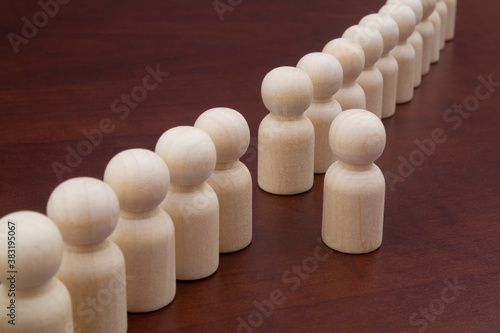 Bild auf Leinwand Wooden figures of people stand in a row