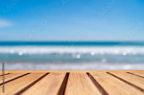 Selective focus of old wood table with beautiful beach background for display your product.