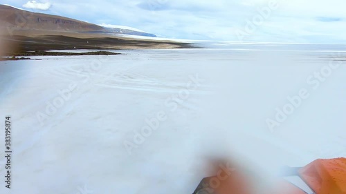 View of frozen landscape of Icelandic glacier from camera mounted on bonnet of 4x4 buggy car. Water drops and dirt deposited on the camera.