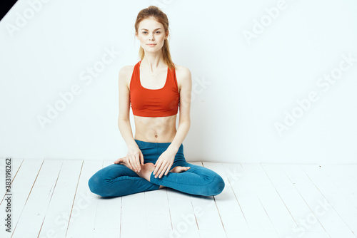 Fototapeta Naklejka Na Ścianę i Meble -  athletic woman in pose on the floor exercise gymnastics performance light background