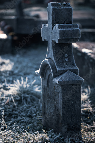 Stone grave tomb cross monument in a morning autumn frost as All Souls Day, All Saints Day background