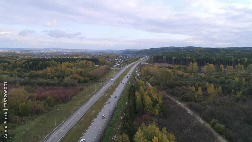 In the shot you can see cars going on highway road. The road goes through the autumn forest. Trees with yellow and green leaves. Autumn cloudy day. Aerial view
In the shot you can see cars going on highway road. The road goes through the autumn forest. Trees with yellow and green leaves. Autumn cloudy day. Aerial view