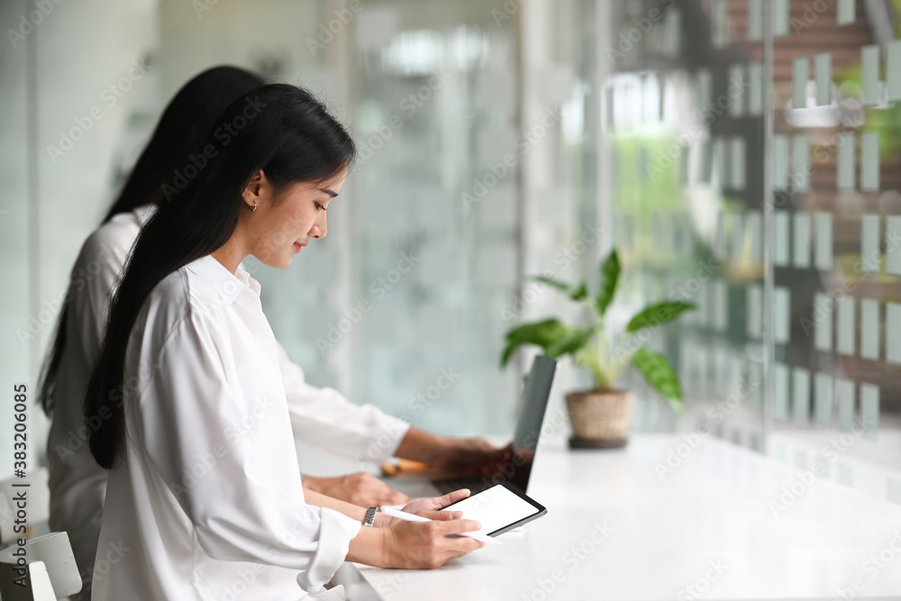 Young startup business group working as team to find solution to problem and using tablet with white screen. Young startup business group working as team to find solution to problem and using tablet with white screen.