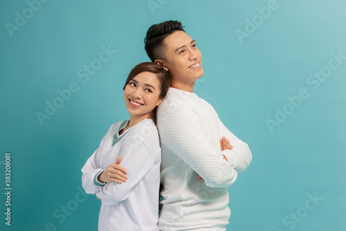 Happy loving couple. Studio shot of beautiful young couplestanding back to back and smiling