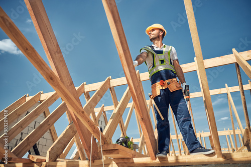 Cheerful bearded man looking upwards at sky