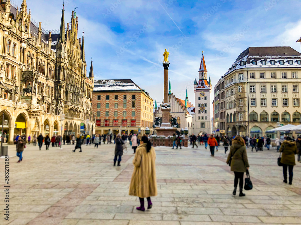 Fototapeta premium Pedestrian zone with shops, restaurants, city hall and historic architecture in downtown Munich, Germany around Marienplatz with landscaping and flower beds or floral arrangements in shopping area