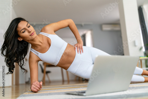 Beautiful young fit woman doing exercises at home. Fitness, healthy lifestyle, sport concept