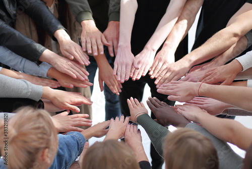 group of diverse people joining their hands in a circle.