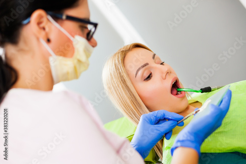 Fototapeta Naklejka Na Ścianę i Meble -  Young woman at dentist. Dentist is repairing her teeth.