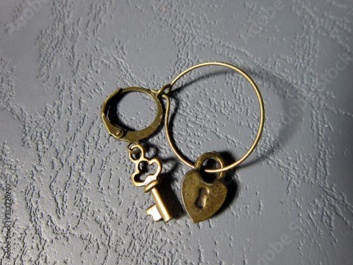 Metal necklaces in the form of keys and locks on a gray background ..
