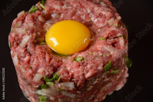 Beef tartare with raw egg, and onions, fresh herbs. French cuisine