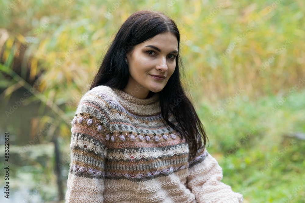 Black-haired woman posing in autumn park in knitted sweater
Black-haired woman posing in autumn park in knitted sweater