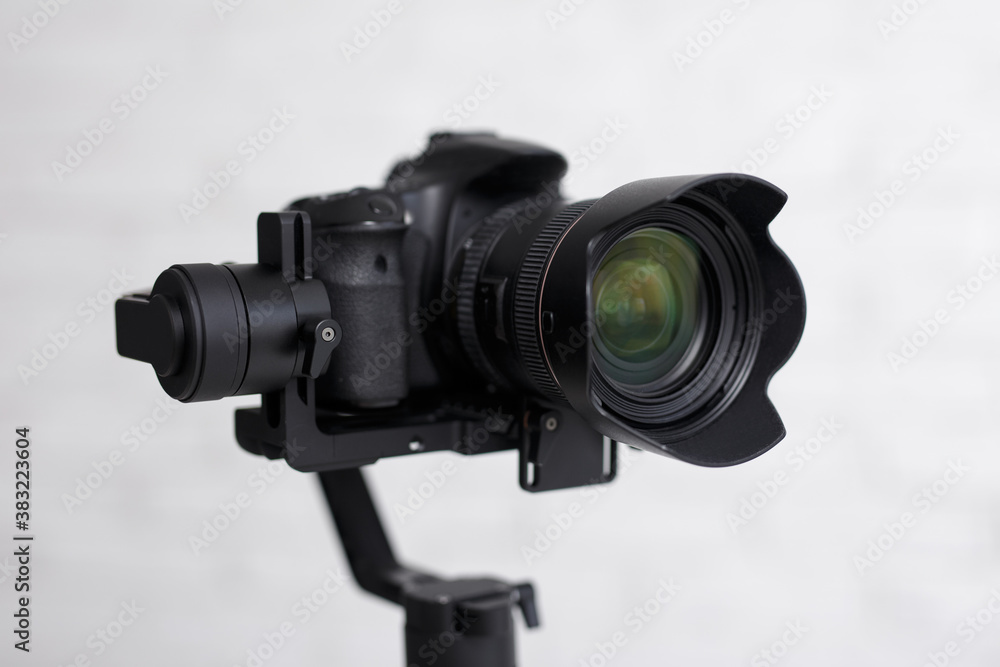 photography or videography kit - close up of modern dslr camera on 3-axis gimbal stabilizer over gray