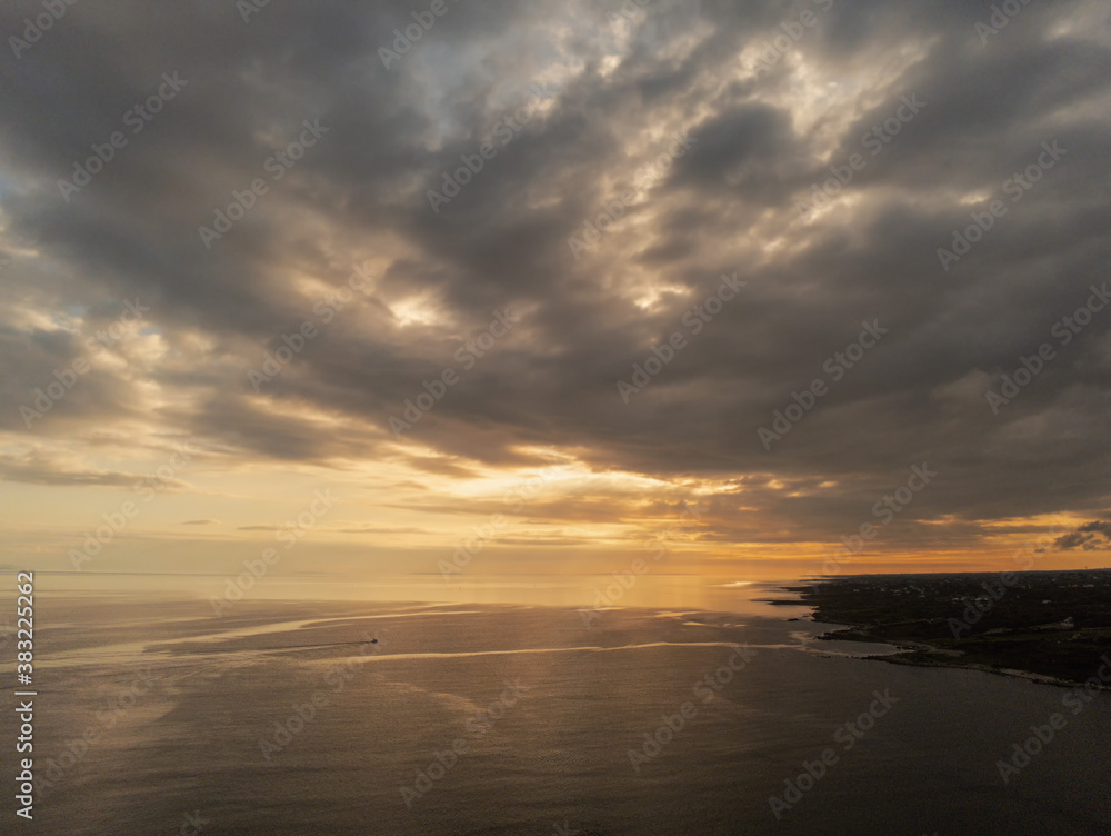 Aerial drone view on West coast of Ireland at sunset. County Galway, Warm cloudy sky over ocean. Calm and peaceful atmosphere