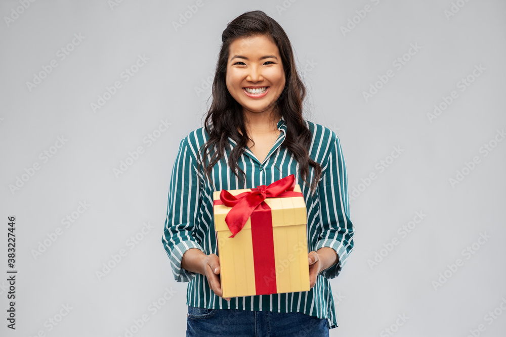 birthday present and surprise concept - happy asian young woman with gift box over grey background birthday present and surprise concept - happy asian young woman with gift box over grey background