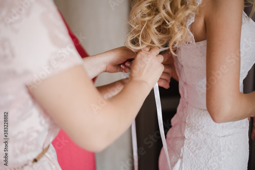 tying a wedding dress, bride in wedding dress, gathering the bride