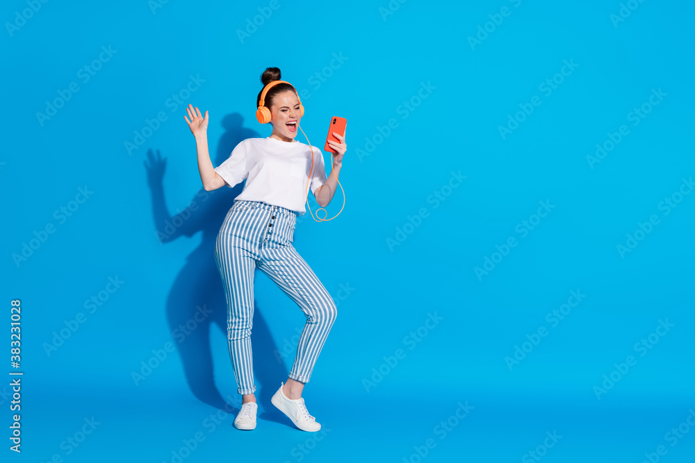 Full length body size view of her she nice attractive pretty glad cheerful cheery girl listening bass soul jazz dancing having fun weekend isolated on bright vivid sine vibrant blue color background Full length body size view of her she nice attractive pretty glad cheerful cheery girl listening bass soul jazz dancing having fun weekend isolated on bright vivid sine vibrant blue color background