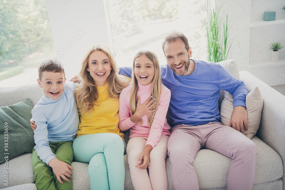 Photo of dream comfort family sit couch mom dad two kids boy girl watch tv laughing in house indoors Photo of dream comfort family sit couch mom dad two kids boy girl watch tv laughing in house indoors