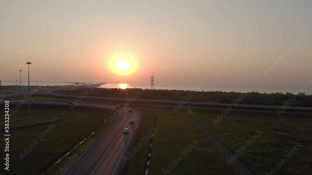 cars drive on the way leaving in the sunset towards the sea cars drive on the way leaving in the sunset towards the sea