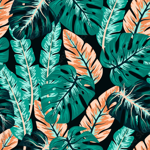 Trend seamless pattern with colorful tropical leaves on a dark background. Creative abstract background. Exotic wallpaper, Hawaiian style. Jungle leaves. Botanical pattern.