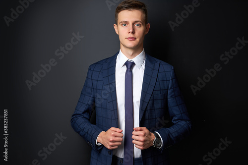 attractive caucasian man in formal stylish suit posing at camera isolated on black background, confident business person